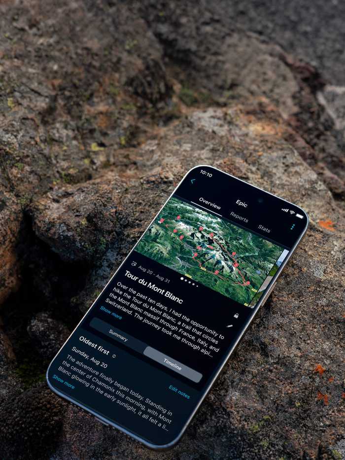 Smartphone resting on a rock, displaying a Tour du Mont Blanc route map and travel journal
