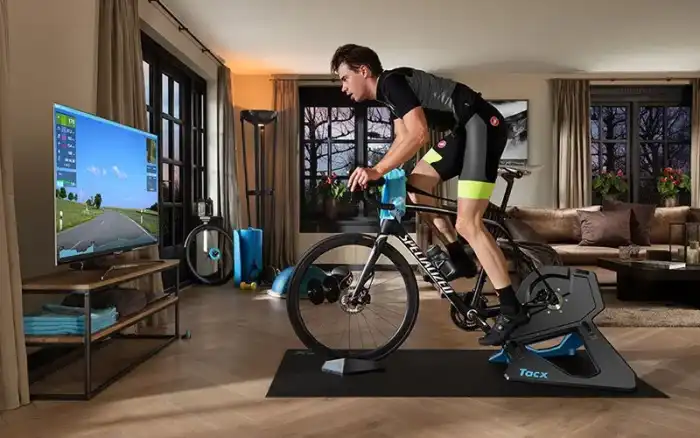 Férfi kerékpáros Tacx NEO 2T Smart okosgörgőn edz nappaliban